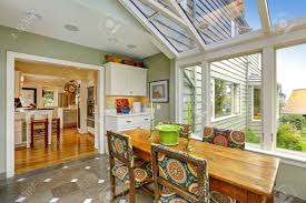 As part of the project, the homeowners replaced the deck flooring material with composite decking, which gave us the opportunity to run that material into the addition as well, giving the room a seamless indoor / outdoor transition. Sunroom Patio Area With Transparent Vaulted Ceiling Wooden Dining Table With Colorful Chairs Stock Photo Picture And Royalty Free Image Image 31851591