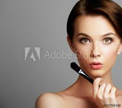 young woman applying foundation