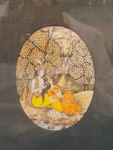 A Rajasthani or Pahari miniature painting — likely Krishna and Radha in a garden. Oval composition, gold leaf trees, hand-painted on paper or old manuscript. Style looks like 19th–early 20th century. #IndianMiniaturePainting #