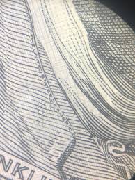 The hundred dollar bill says “The United States of America”