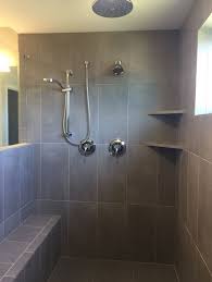 In the past, bathroom designers used lots of tile on the walls, but today that's considered kind of dated. Skybridge Gray 12x24 Wall Tile Installed Vertical Stacked In Master Garden Shower Shower Tile Gray Shower Tile Vertical Shower Tile