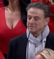 Fans Are Desperately Trying To Identify The Jaw-Dropping New Mexico Lobos  Fan Spotted Behind Rick Pitino Full story via 🔗 in comments. 👇