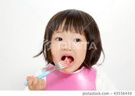 Little girl eating watermelon pierced with fork...