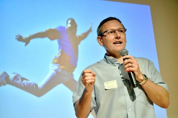 WHIS founder Gareth Presch presenting community health innovation, AI generated
