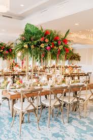 Tropical Garden Wedding Centerpiece With Palm Leaves Fronds Wood Farm Tables Tropical Wedding Decor Wedding Floral Centerpieces Garden Wedding Centerpieces