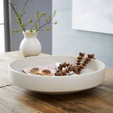 A coffee table is a low table designed to be placed in a sitting area for convenient support of beverages, remote controls, magazines, books (especially large, illustrated coffee table books), decorative objects, and other small items. Pure White Ceramic Centrepiece Bowl West Elm Canada