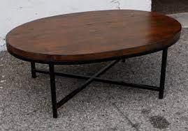 Oval Dark Brown Polished Wooden Coffee Tables With Four Black Metal Legs On Grey Floor Oval Wood Coffee Table Coffee Table Wood Dark Wood Coffee Table