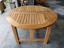 Black garden dining table with parasol hole in heart. Teak Garden Furniture Tirto Furniture