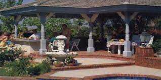 Covered outdoor stone kitchen with patio dining area. Outdoor Kitchens This Old House
