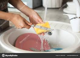 woman washing dishes kitchen sink