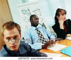 Businessman Sitting In Front Of A Flip Chart At A Boardroom