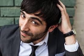 A Man With Dark Hear And Beard Looking Serious Directly Into Camera" by  Stocksy Contributor "J Danielle Wehunt"