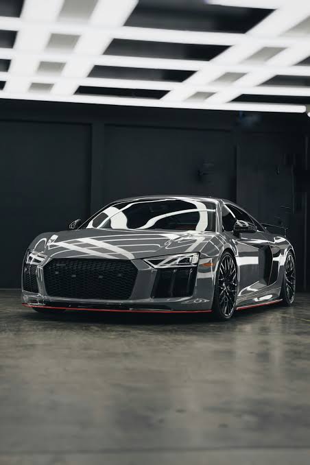 Silver sports car outside a garage