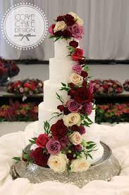 Rustic White Iced Wedding Cake With Fresh Floral Cascade In Shades Of Burgundy Mauve And Floral Wedding Cakes Burgundy Wedding Cake Wedding Cakes With Flowers