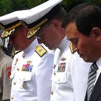 Commander, U.S. Naval Forces Korea, Rear Adm. James Wisecup, right center,  and others bow their heads in silence during a wreath laying ceremony at  Gen. MacArthur Statue in Freedom Park.