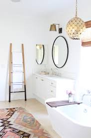Look for exaggerated shapes or cubes when selecting lighting fixtures for your bathroom, like arched brass wall sconces seen here. Bohemian Bathroom Lighting Novocom Top