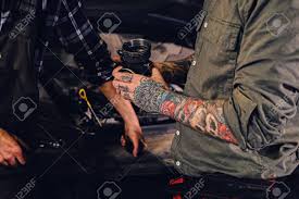 To better enhance your online search, use search engine suggestions. Close Up Image Of Two Mechanics With Tattoos On Arms Fixing Car S Engine Parts In A Workshop Stock Photo Picture And Royalty Free Image Image 79000819