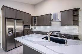 A transitional style kitchen in wellington, florida features a beautiful contrast of light cabinets with a dark island. Dark Grey And White Quartz Countertop Modern Kitchen Grey Kitchen Cabinets Gray And White Kitchen Dark Grey Kitchen Cabinets