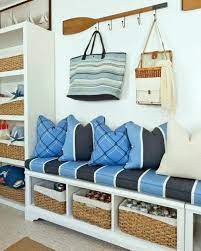 A vintage bench with drawers, embroidered pillows, a lantern and an arrangement of rope and driftwood anchors on the wall. Simple Coastal Entryway Storage Ideas With Benches Wardrobes Wall Shelves Diy Shop The Look Coastal Entryway Beach Towel Storage Beach House Decor