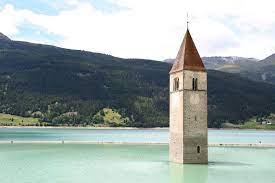 The series is set in the iconic location of curon venosta, featuring the characteristic submerged belltower. The Submerged Church Of Curon Venosta Curon Venosta Italy The Steeple Of The Church Juts Out In Lake Resia The Abandoned Places Places Abandoned Buildings