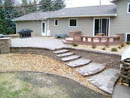 The process of installing this paver patio with a retaining/seating wall is meticulous. Raised Paver Patio With Retaining Walls Stairs Deck And Seating Wall Oasis Landscapes West Fargo Nd