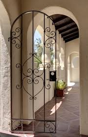 Una puerta de hierro forjado sería demasiado llamativa. Spanish Style Gates Exterior Mediterranean With Spanish Traditional Doorbell Butto Wrought Iron Doors Front Entrances Iron Front Door Wrought Iron Garden Gates