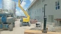 Retroescavadeira Caterpillar e Plataforma elevatória passando