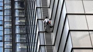 As night fell, a row of powerful spotlights shone on the side of the tower as robert climbed. Spider Man Alain Robert Scales London S Heron Tower Bbc News