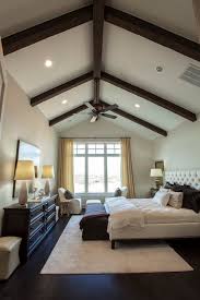 Primary bedroom with green walls and white carpet floors, along with a stunning white ceiling beautiful bedroom of light green tones with ceiling beams and stone background fireplace. Exposed Wood Beams Transitional Bedroom Southern Living