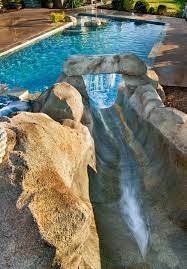 the view going down our slide complete with an additional waterfall as you hit the pool water backyard pool swimming pool designs tropical pool