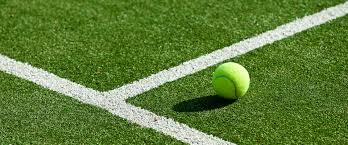 Tennis balls lie in the grass on the court in the background the family plays tennis. Synthetic Grass Tennis Court Maintenance Tennis Court Maintaniers