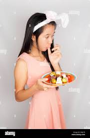 Cute Asian bunny girl hold plate of Easter eggs and chocolate Stock Photo -  Alamy