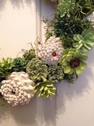 Lets Get Ready For Spring This Unique Wreath In Many Shades Of Green With A Cream Flower Accent Will Make Y Painted Pinecones Pine Cone Decorations Pine Cones