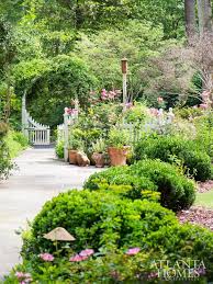 Playful Groupings Of Ball Boxwood Frame The Courtyard Garden S Bluestone Path An Array Of Annuals Accent Cottage Garden Design Courtyard Garden Cottage Garden