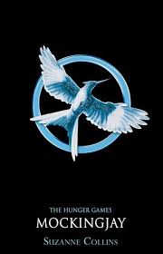 The Cover Of The Hunger Games Trilogy Is Black Featuring A Gold Mockingjay A Crossbreed Born From Hunger Games Book Cover Hunger Games Books Mockingjay Book