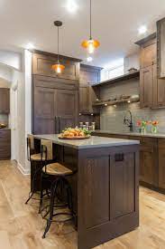 The dark grey cabinets don t feel overbearing but rather inviting and riveting. Craftsman Kitchen With Tree Stump Butcher Block Two Islands Lauren Levant Hgtv Brown Kitchen Cabinets Dark Wood Kitchen Cabinets Kitchen Remodel