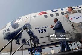 Hank Aaron speaks as Delta Air Lines CFO Ed Bastian looks