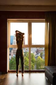 Woman Undressing In Front Of Window