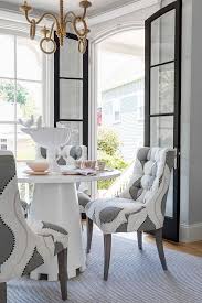 Not only do dining chairs with arms make a sophisticated statement during mealtime, they also encourage proper posture—providing support where it's needed. Round White Dining Table With White And Gray Tufted Chairs Transitional Dining Room