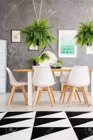 The general rule for hanging dining room chandeliers is that the bottom of the fixture should hang between 30 and 34 from the tabletop assuming you have an 8' ceiling. Cozy Dining Room Interior With An Elegant Dining Table And Fern Plants Hanging Over The Table Stock Photo Picture And Royalty Free Image Image 97990698