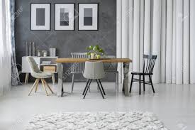 But a good rug can bring color, texture, warmth and style to the dining room—making the hunt well worth the effort. Patterned Carpet In Grey Dining Room With Wooden Table And Chairs Next To Cupboard And Paper Tubes Stock Photo Picture And Royalty Free Image Image 93191318