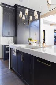 Two Small Farlane Chandeliers Light A Black Oak Kitchen Island Fitted With Cabinets Donning Brass Pull Kitchen Design Black Kitchen Island Contemporary Kitchen