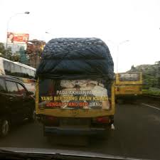 Jika kamu berkendara di belakang truk muatan, terkadang ada pemandangan menggelitik yang tidak bisa dielakkan. Tulisan Belakang Mobil Truk Ini Absurd Sekaligus Sarat Makna Hidup
