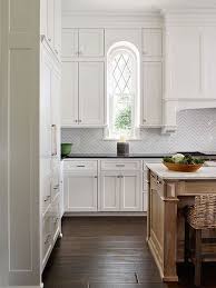 White Kitchen With Herringbone Tile Backsplash And A Light Wood Island Kitchen Design Kitchen Cabinet Design Kitchen Design Traditional White
