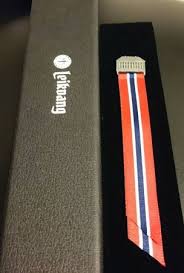 Mai sløyfe til gutt i sølv med slikebånd i rødt, hvitt og blått. 17 Mai Sloyfer Skarnes Ur Gull B Johnsen Butikk Verksted Med Ur Gaver Smykker Solv Gull Bunadsolv Og Annet Tilbehor Til Bunader I Hele Landet Stjernekikkert Titan Vekkerklokke Veggur Optisk Lesebriller