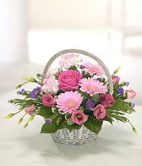 Young woman florist working outdoors at the nursery gathering flowers in a large wicker basket she is holding in her hands stand young woman florist working. Gift Of Flowers Same Day Delivery Standard Sized Basket In Soft Colours Oth Basket Flower Arrangements Flower Arrangements Diy Spring Floral Arrangements
