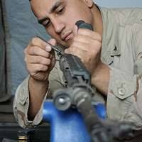 Arsenal Machinist Harold Mosher is inspecting a muzzle