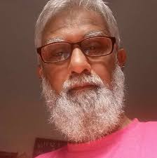 A portrait photographer sits next to his homemade camera