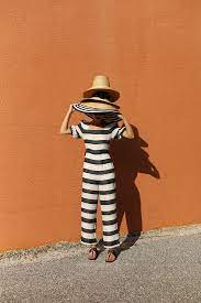 Blair Eadie Wearing A Striped Jumpsuit Gucci Sandals And All Of The Hats Click Through For More Fun Sun Hats A Atlantic Pacific Warm Weather Fashion Style