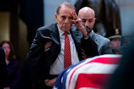Former senator bob dole is helped out of his wheelchair to salute the casket of former president george h.w. Kkqyjl5xe0deum